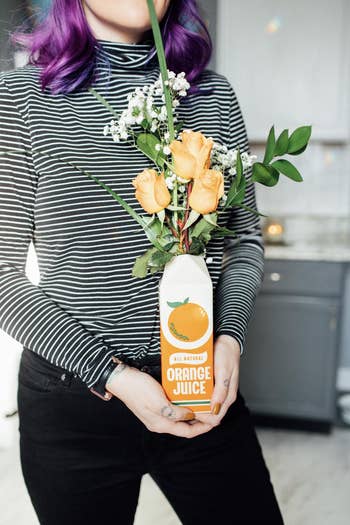 reviewer holding the orange juice vase
