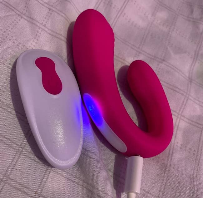 pink vibrator next to white wireless remote