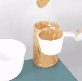 gif of someone using the pb-jife to scoop peanut butter out of a jar and into a measuring cup