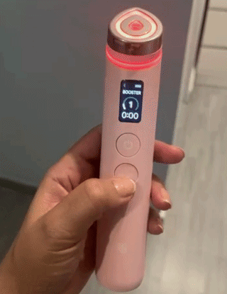 Hand holding a skincare device with a digital display and circular top, suitable for personal beauty treatments