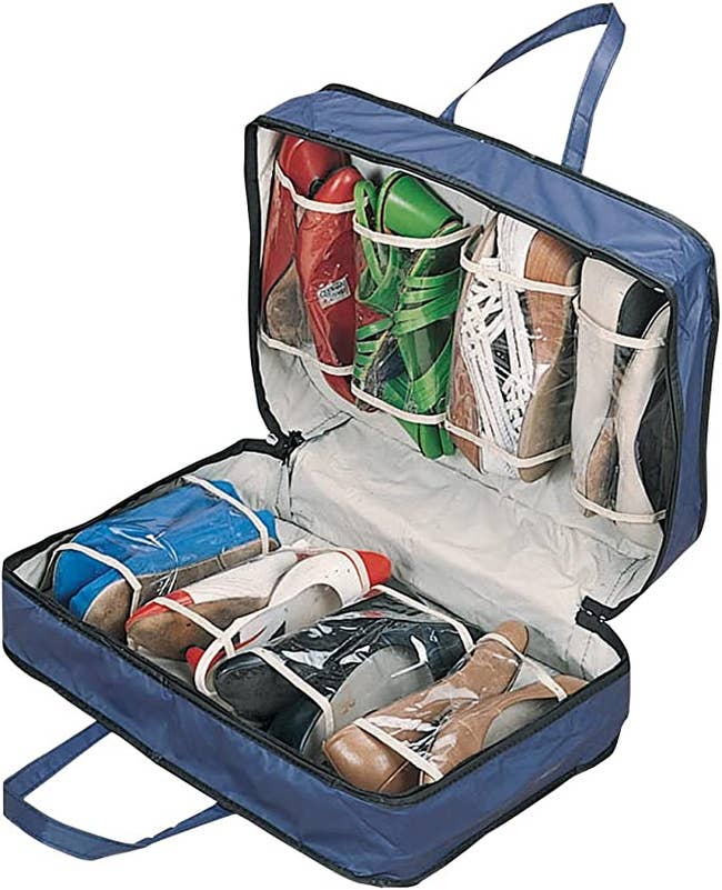 The travel bag opened and filled with various pairs of shoes