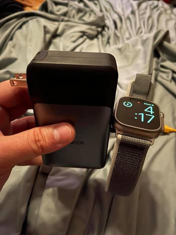 same reviewer holding it showing how it also charges their Apple Watch
