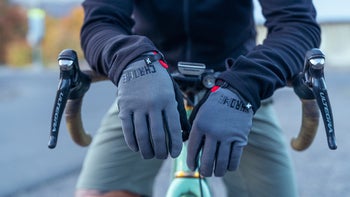 model wearing bike gloves, resting on handlebars