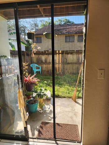 A sunny patio viewed through a screen door