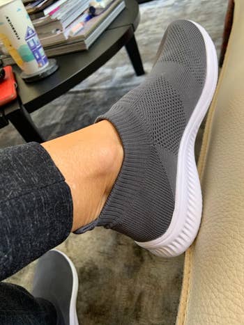 reviewer wearing the grey sneakers