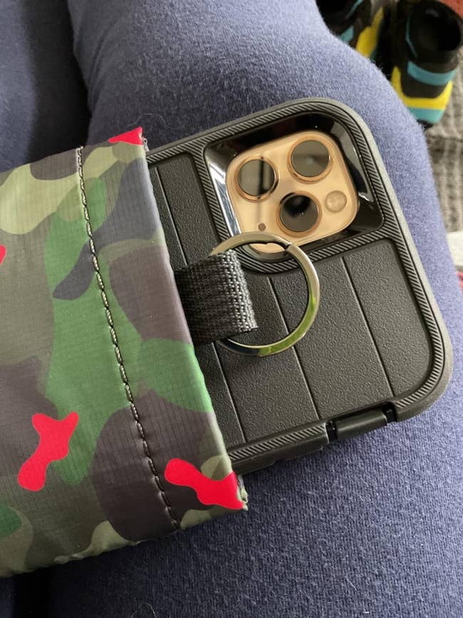 Smartphone partially pulled retired of a camo-patterned thermal telephone case