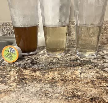 reviewer image of three cups of water that starts dark brown and ends up clear