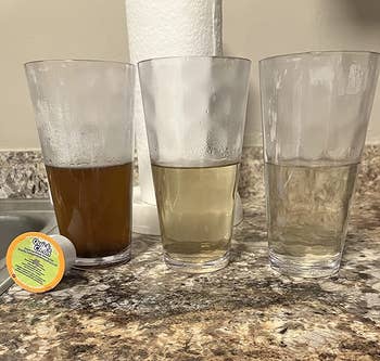 reviewer image of three cups of water that starts dark brown and ends up clear