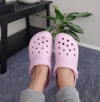 reviewer wearing light pink crocs