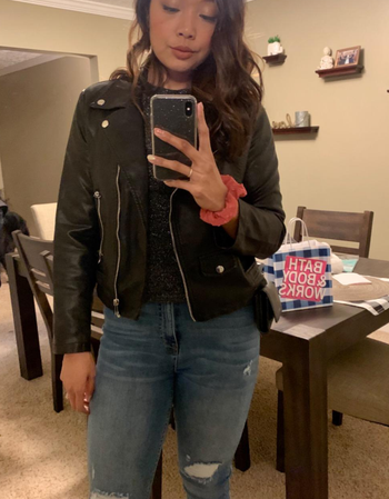 A reviewer wearing the black jacket with jeans