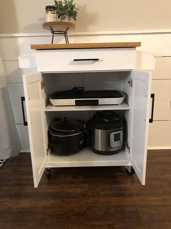 A reviewer's white island open showing the shelves inside