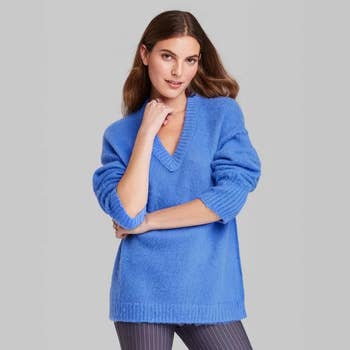 a model wearing a blue v-neck sweater
