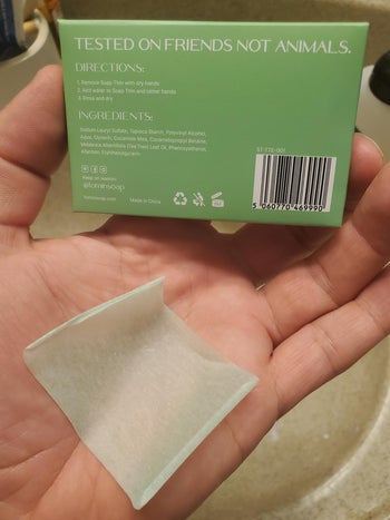 reviewer photo of a green soap sheet on their palm