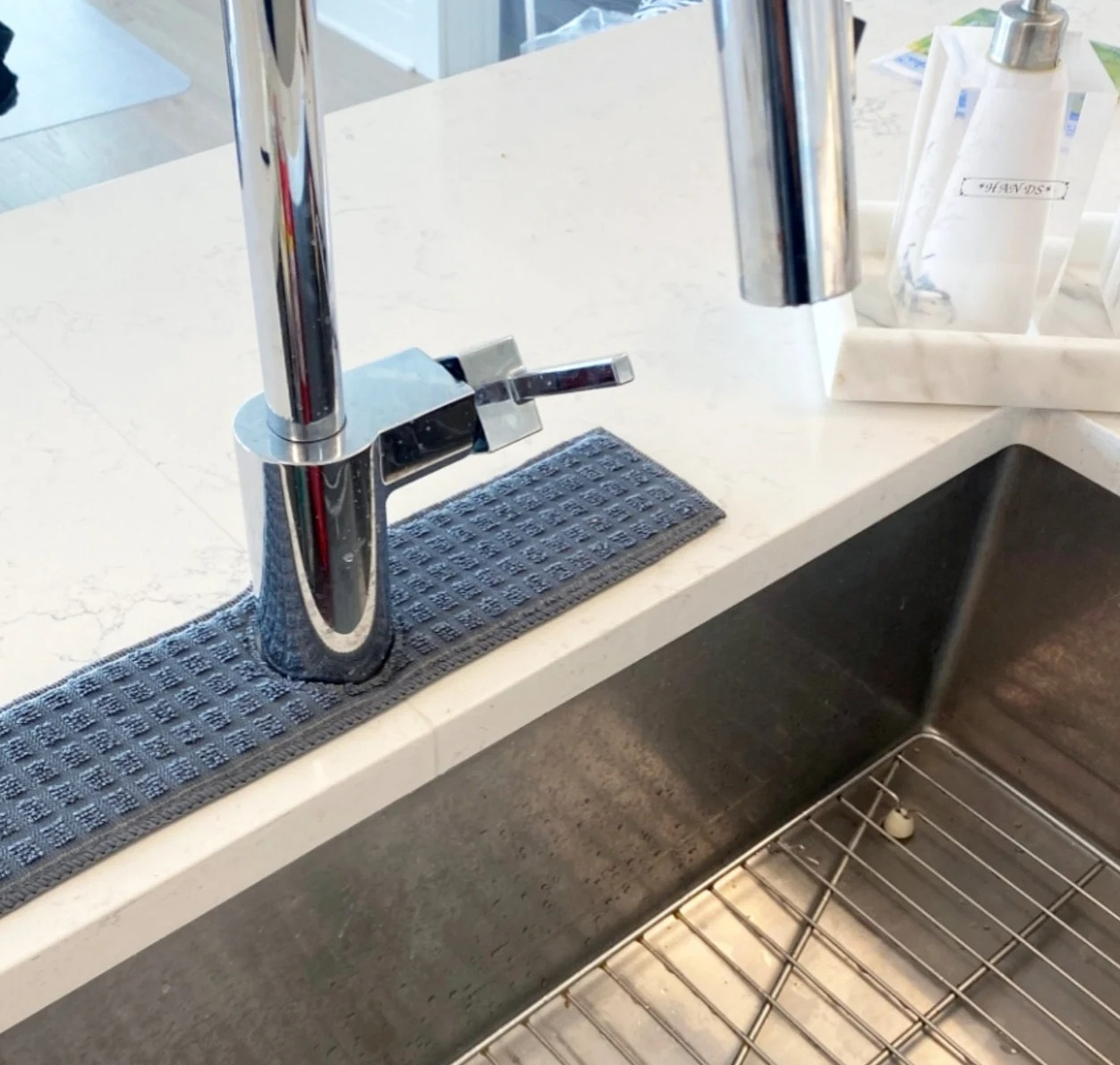 the blue splash catcher placed around a kitchen sink faucet