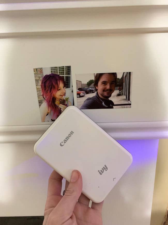 image of reviewer holding up the canon mini printer next to two small printed pictures