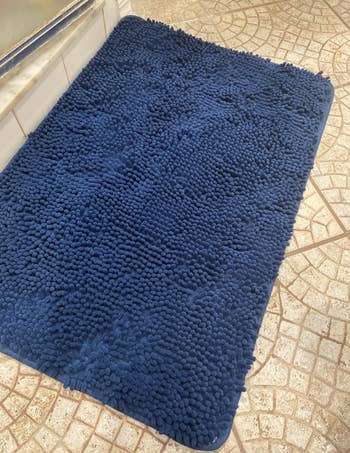 Reviewer using the blue rug in their bathroom