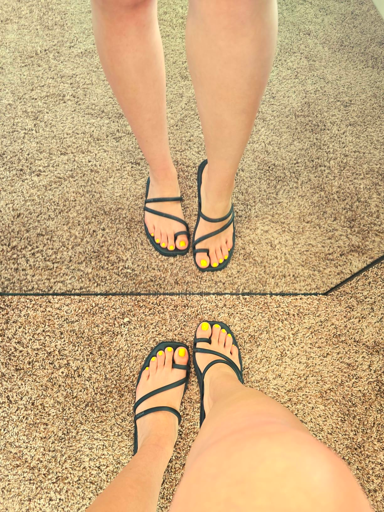 Person wearing strappy sandals with yellow-painted toenails, lasting  successful  beforehand   of a reflector  connected  a carpeted floor