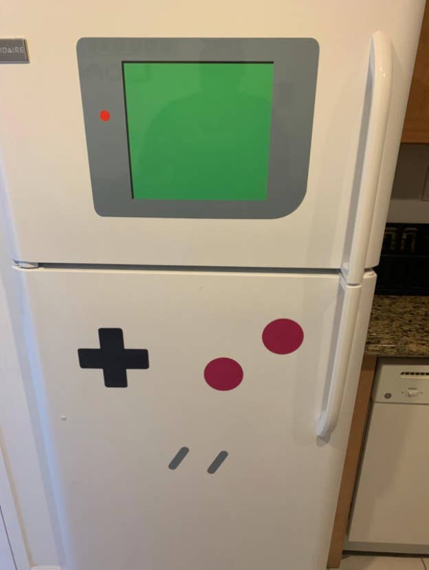 white fridge with the Gameboy window dry-erase board and magnets that look like Gameboy buttons