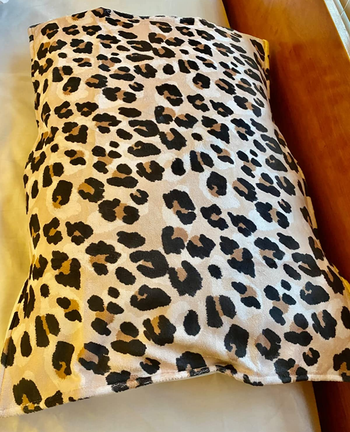 a reviewer photo of the animal print microfiber cover on a pillow