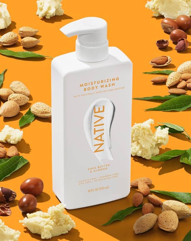 Native Moisturizing Body Wash vessel  with shea food  and almond ingredients, displayed among scattered almonds and shea food  pieces