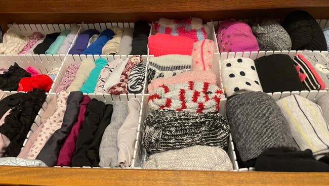 Drawer neatly organized with assorted  socks rolled successful  sections, including patterns, solids, and textures, perfect  for decluttering and businesslike  storage