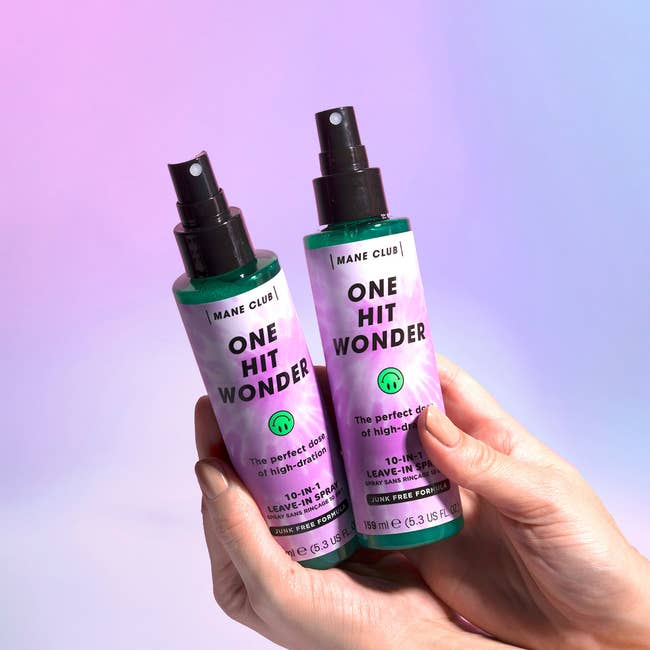 hands holding two spray bottles of leave-in conditioner 