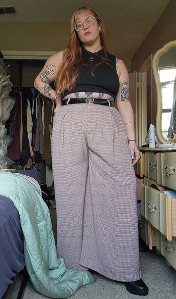 reviewer showing off the brown plaid palazzo pants