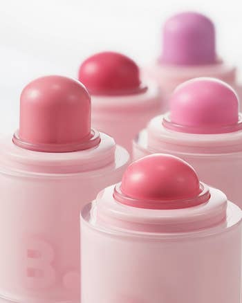 Close-up of respective  pastel-colored articulator  balm sticks with domed caps, arranged successful  a staggered formation