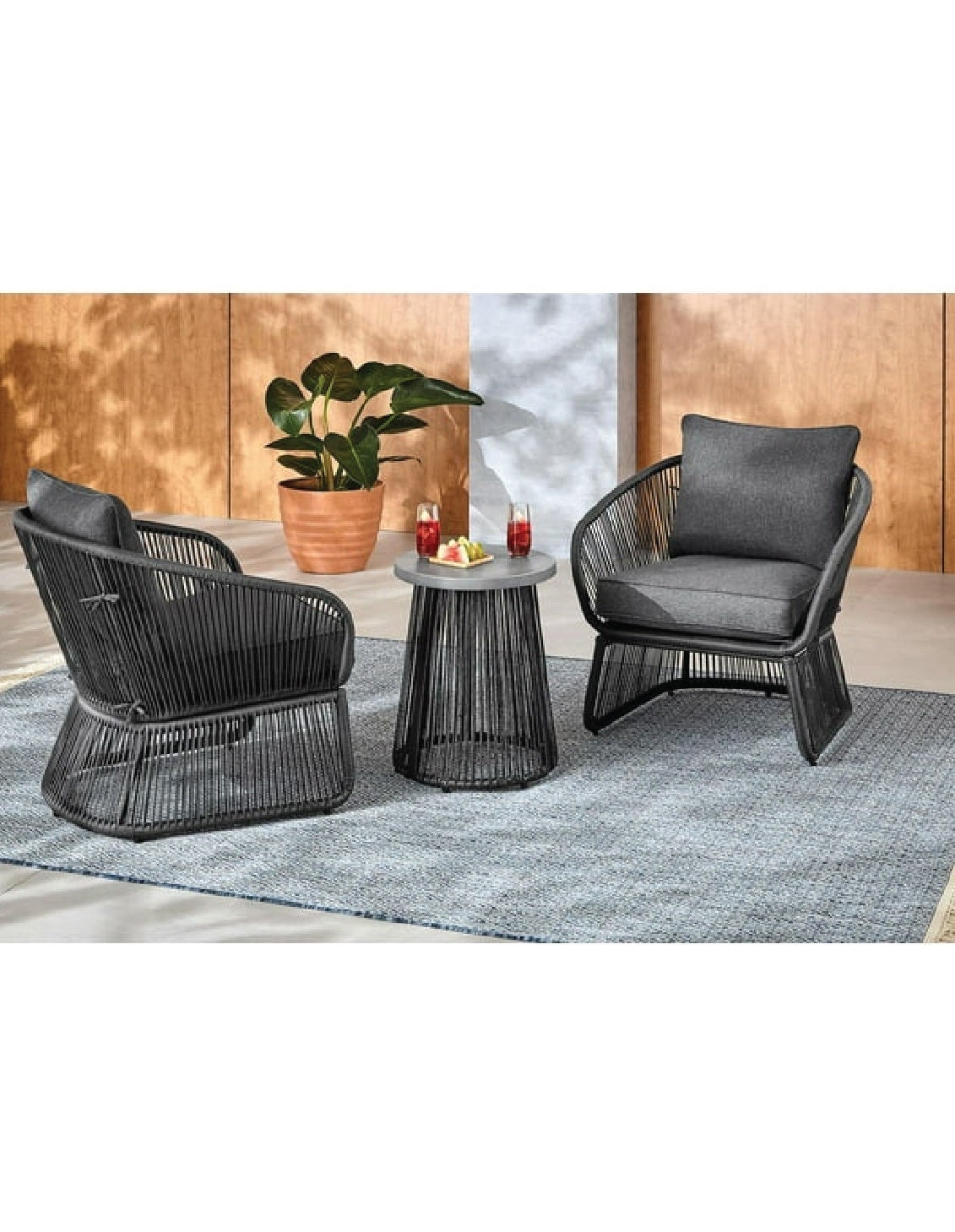 two black wicker chairs and small black table