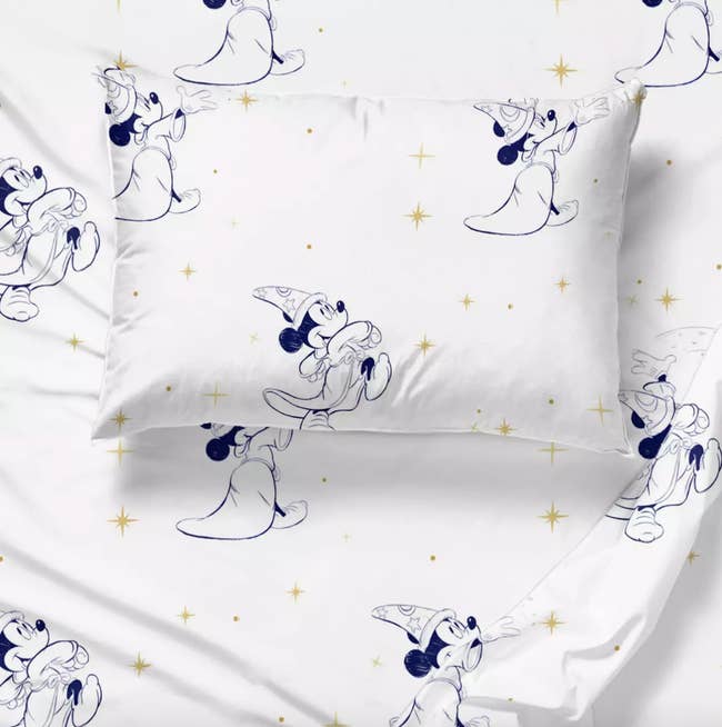 white sheets with a sketch outline of sorcerer mickey and yellow sparkles