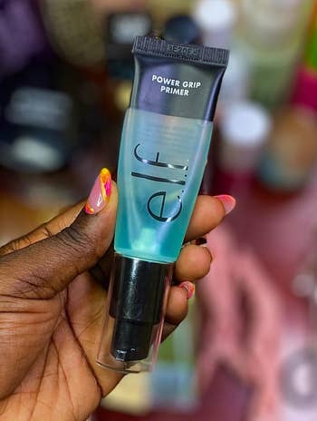 Reviewer holding e.l.f powerfulness grip primer