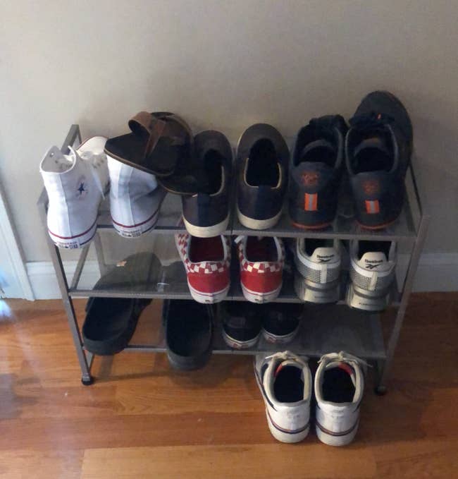 A tiny  footwear  rack with assorted  casual and diversion  shoes neatly organized successful  pairs