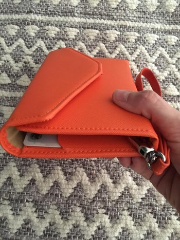 reviewer showing how thin the wallet is when closed
