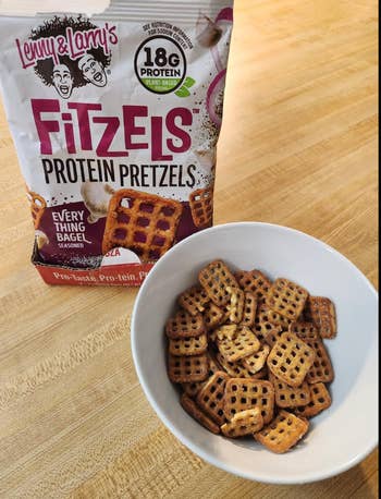 Lenny & Larry's FitZels Protein Pretzels successful  a vessel  and packaging connected  a table. Text highlights 18g macromolecule  and 