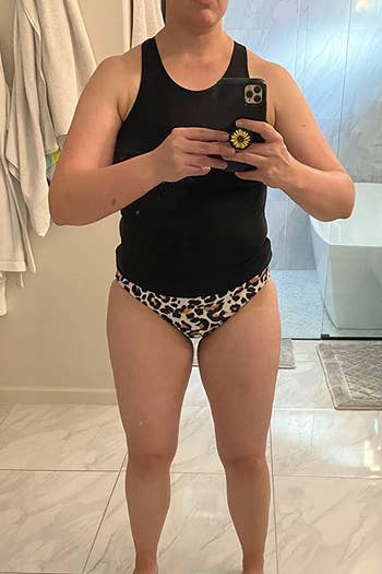 a reviewer wearing the black tankini with leopard bottoms