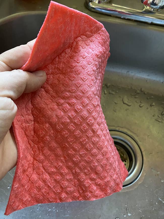 a reviewer holding a pink dishcloth