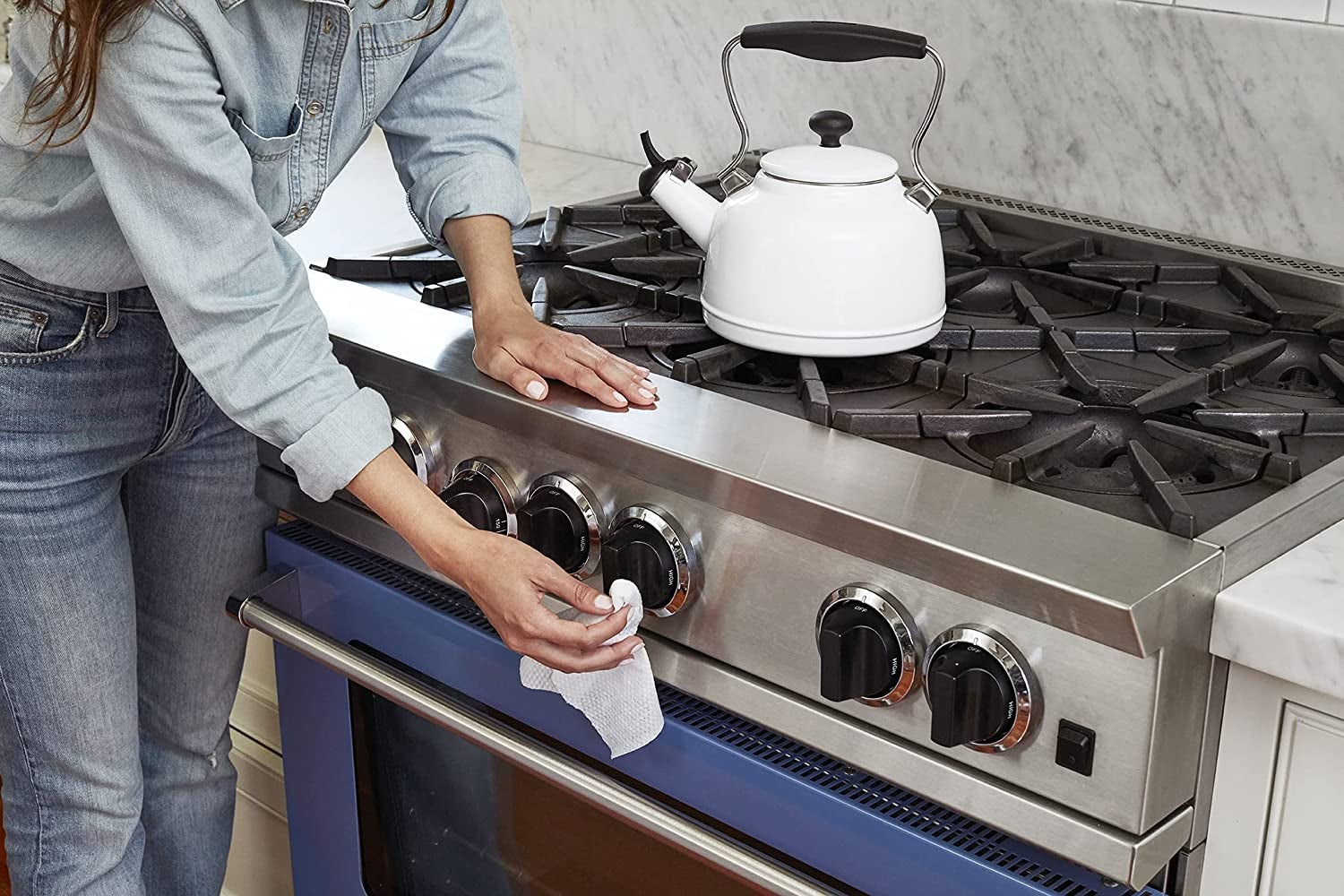 model uses wipe to clean stove handles in kitchen