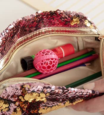 the pink cleaning ball inside of a handbag