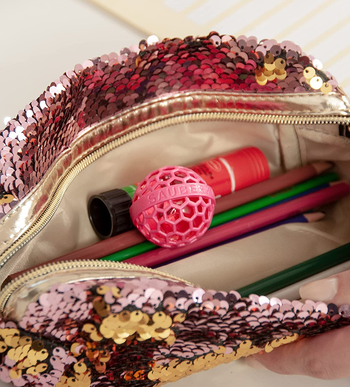 the pink cleaning ball inside of a handbag