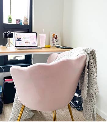The petal chair in a light pink at a desk 