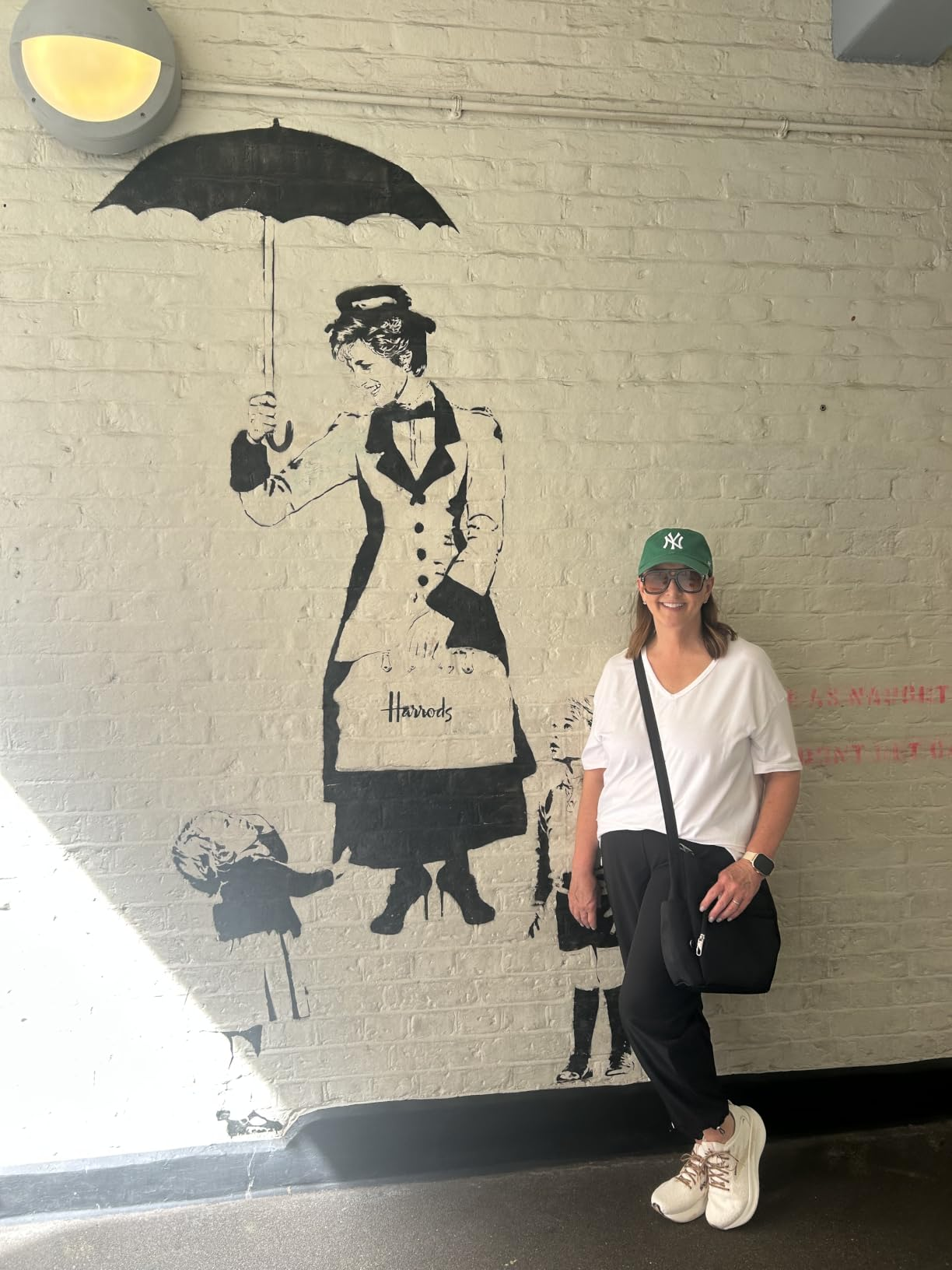 Woman successful  casual attire poses adjacent  to thoroughfare  creation  of a fig  holding an umbrella, resembling a classical  nanny character
