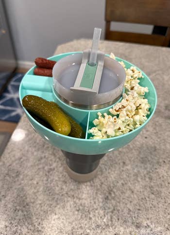 blue version holding popcorn, pickles, and meat 