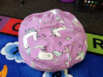 reviewer's bean bag chair with unicorn prints, placed on a play mat