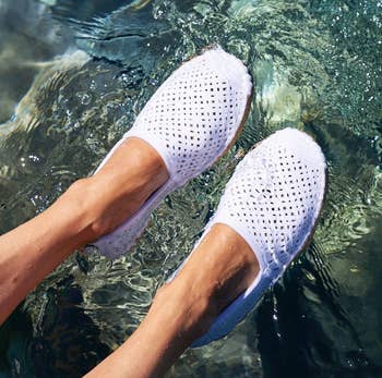 reviewer wearing the white espadrilles in water