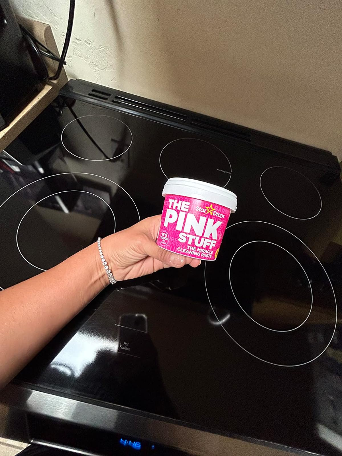 reviewer holding tub of The Pink Stuff