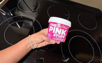reviewer holding tub of The Pink Stuff