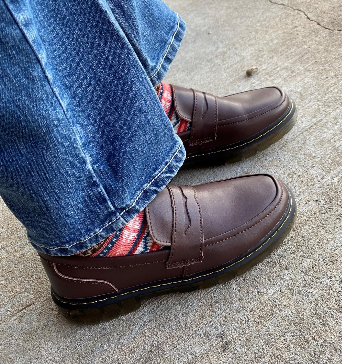 Brown loafers paired with patterned socks and jeans