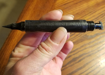 a reviewer photo of a hand holding the dual ended eyeliner tool 