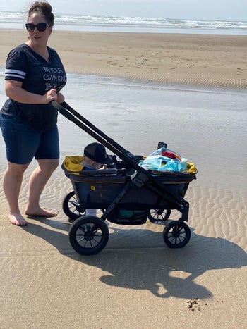 reviewer's photo with the wagon carrying a child and their stuff at the beach