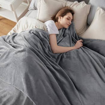 a model sleeping under the gray blanket